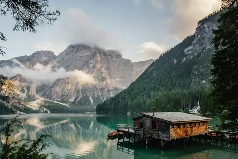 A calm alpine lake surrounded by trees and mountains